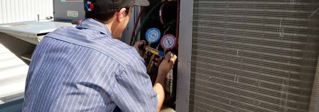 HVAC technician servicing a condenser unit in Euless