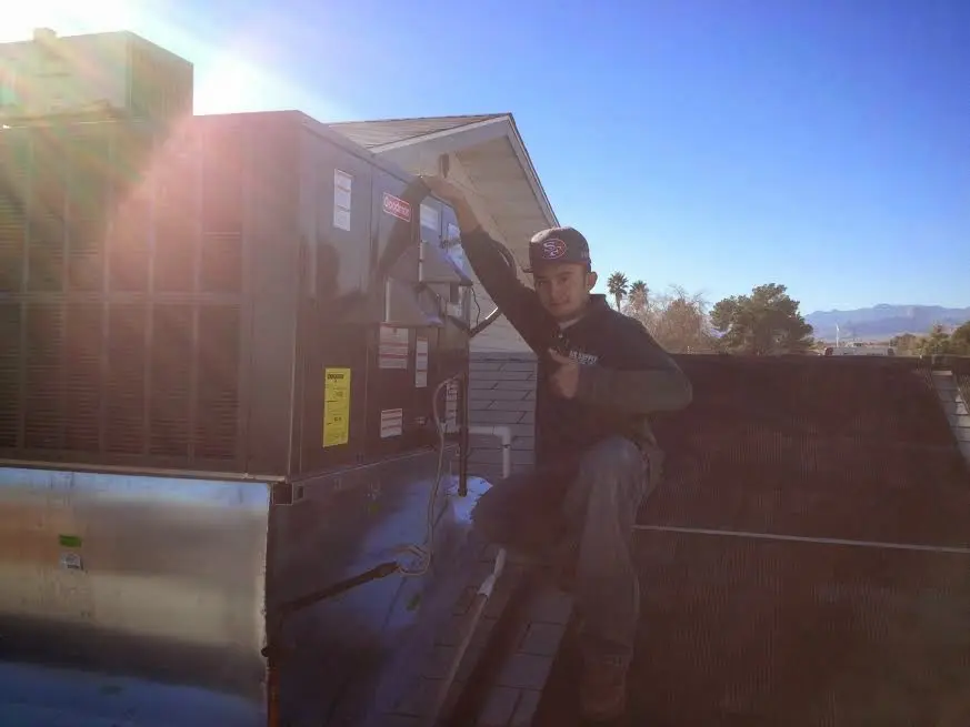 HVAC technician performing Air Duct Repair on a rooftop unit in Euless